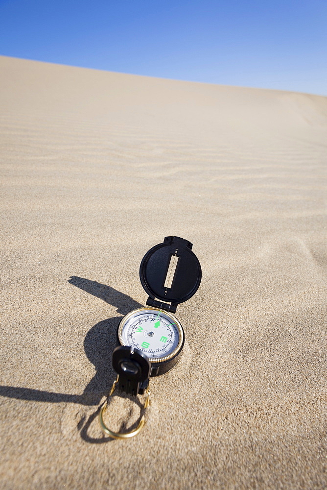 Oregon, Florence, Compass lying on sand dune