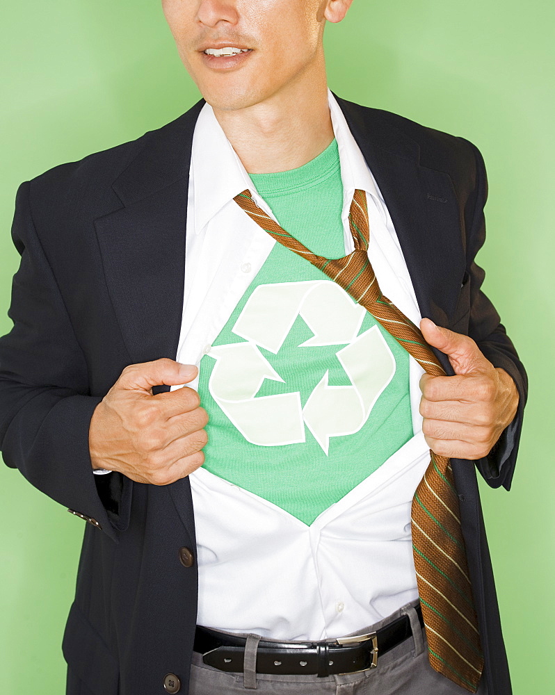 Businessman with wearing t-shirt with recycling symbol under suit, studio shot