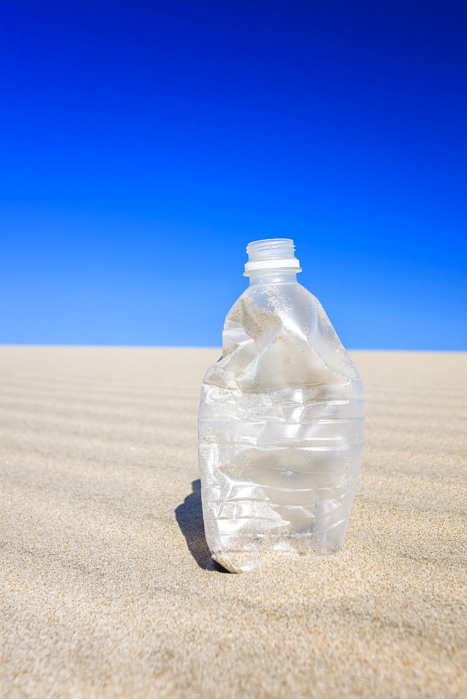 Oregon, Florence, Empty water bottle on sand dune