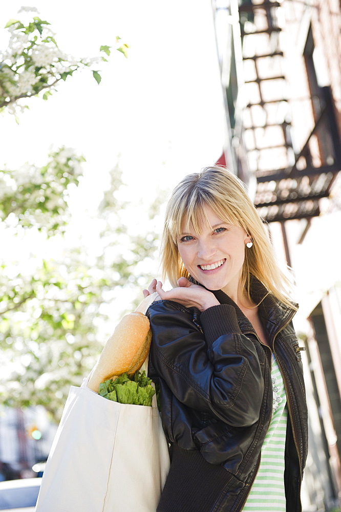 USA, New York, Williamsburg, Brooklyn, Smiling woman carrying shopping bag