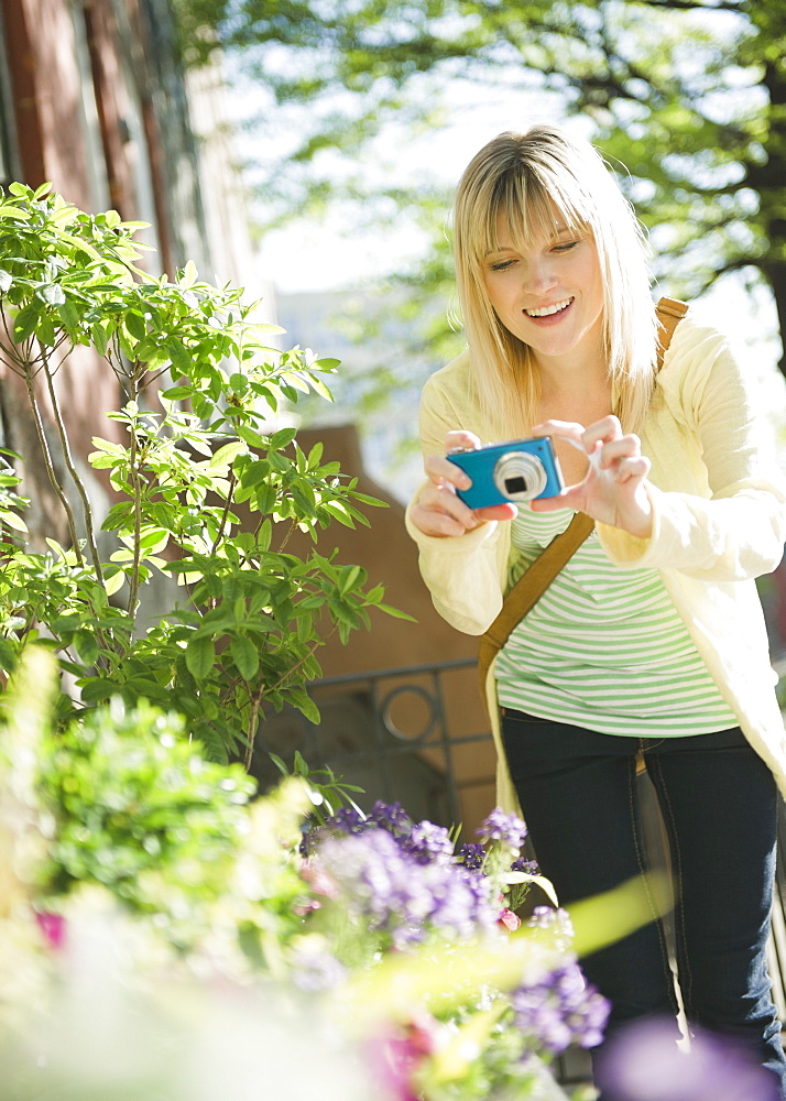 USA, Brooklyn, Williamsburg, Woman photographing flowers