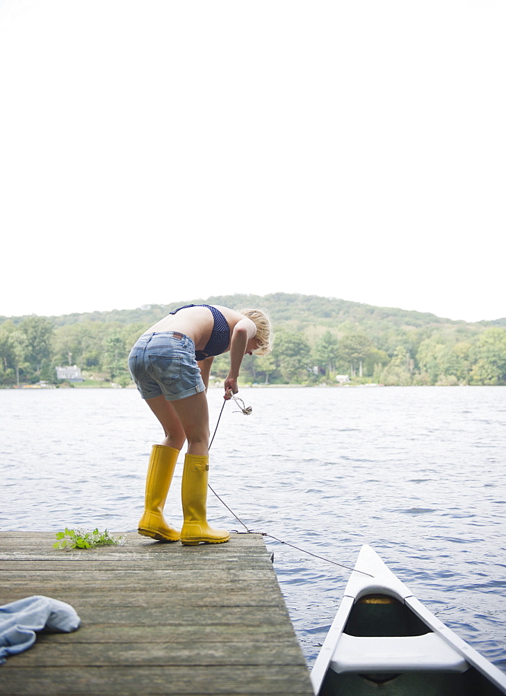 USA, New York, Putnam Valley, Roaring Brook Lake, Rear view of woman mooring boat