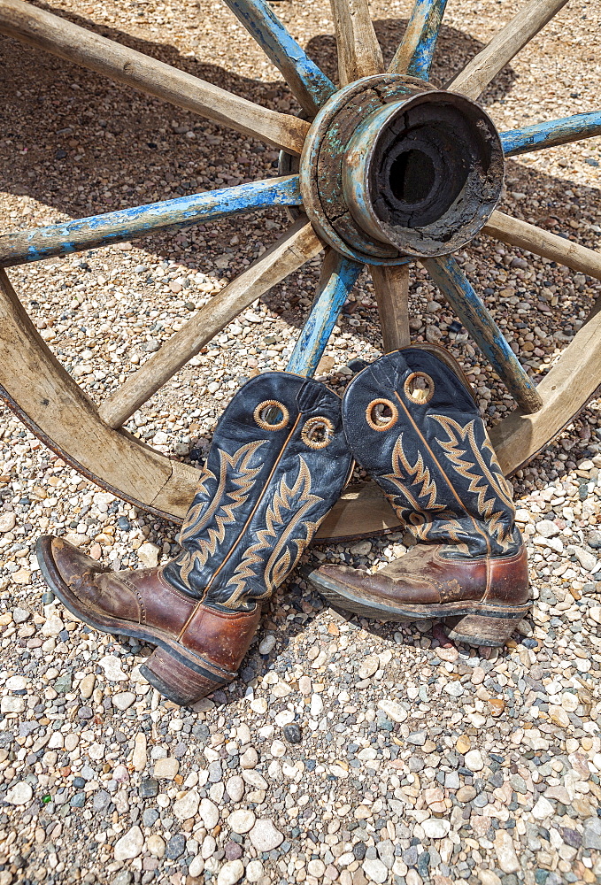 Cowboy boots against wagon wheel