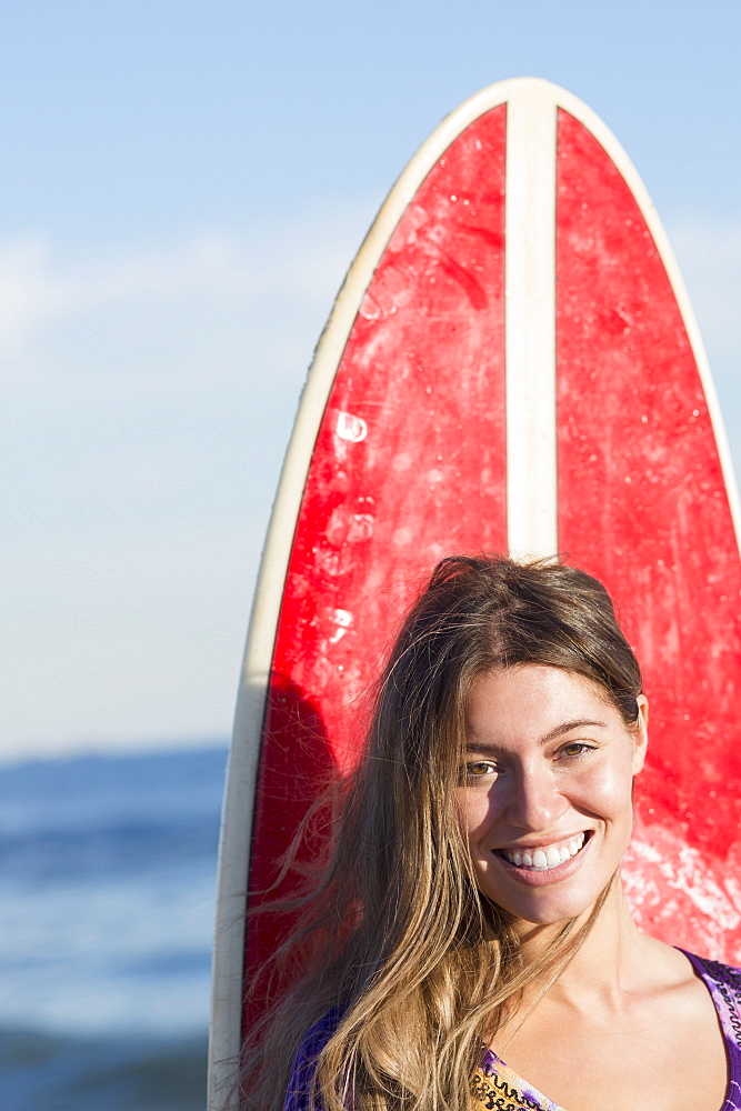 Portrait of woman with surfboard, Rockaway Beach, New York