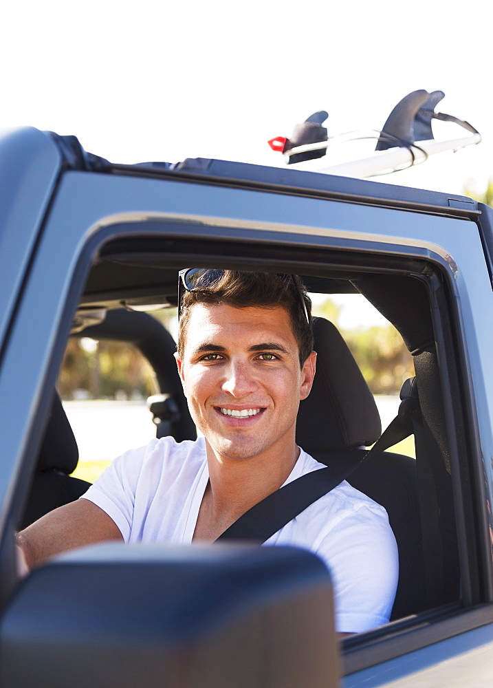 Young man driving car, Jupiter, Florida, USA