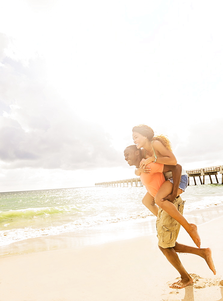 Young couple playing on beach, Jupiter, Florida