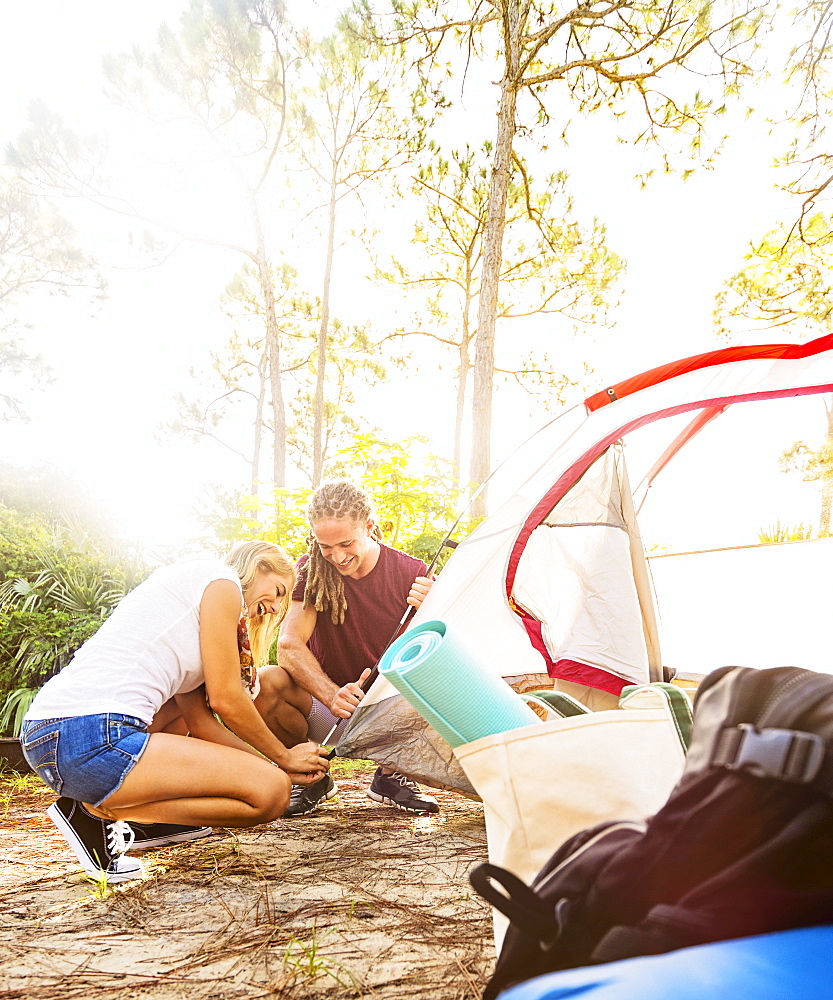 Couple setting up tent in forest, Tequesta, Florida