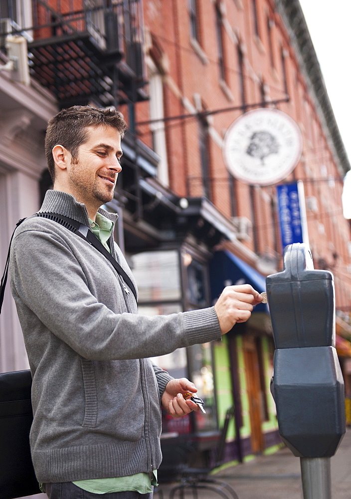 Man inserting coin to parking meter