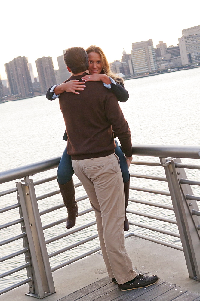 USA, New York, Long Island City, Young couple embracing on boardwalk