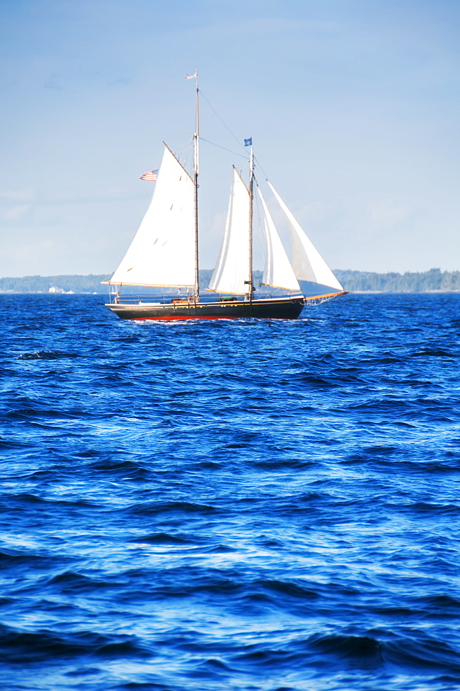 Small yacht sailing on blue sea