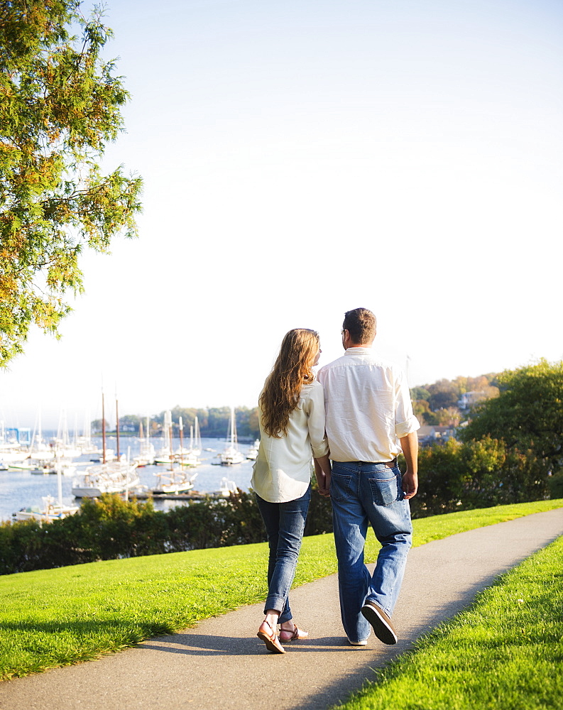Couple walking with harbor in background, Camden, Maine