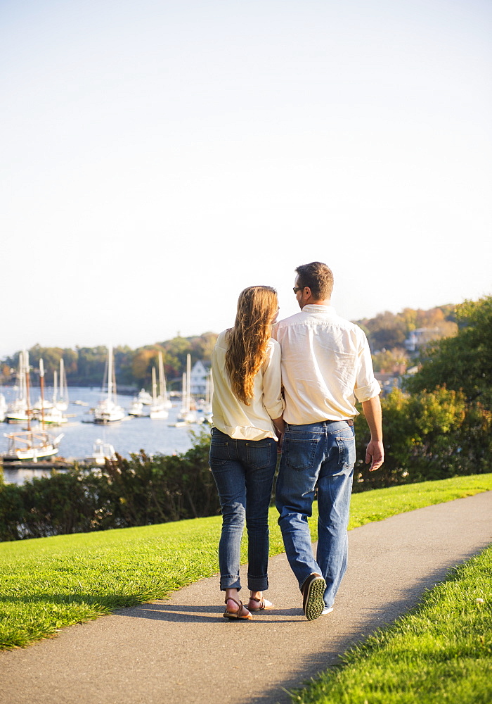 Couple walking with harbor in background, Camden, Maine