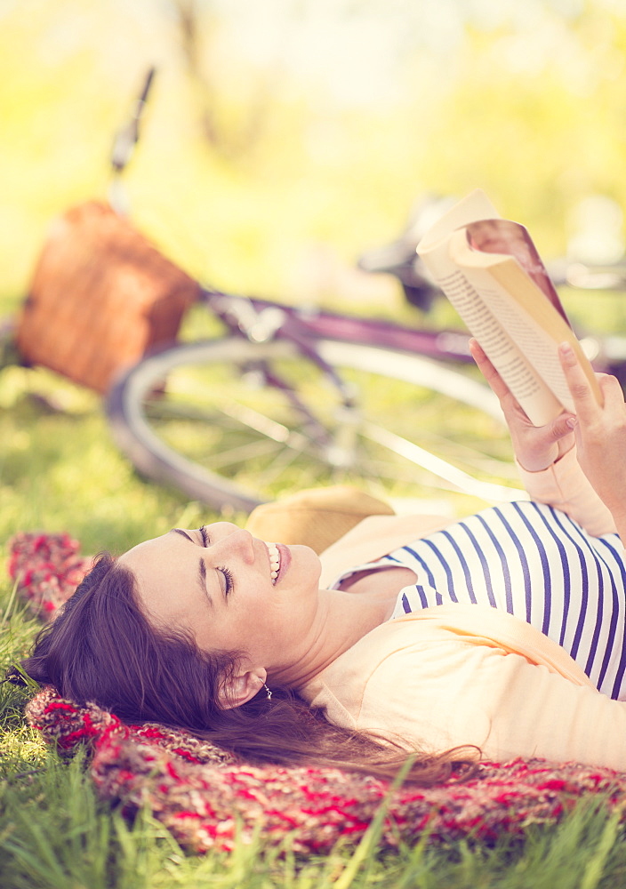 Mid adult woman reading book, Central Park, New York City