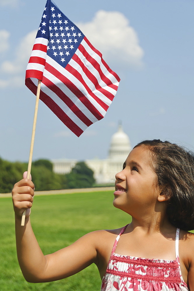 USA, Washington DC, girl (10-11) with US flag in front of Capitol Building