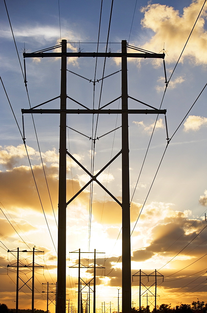 Electrical poles and wires at sunset