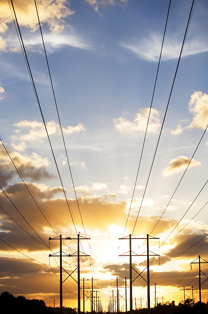 Electrical poles and wires at sunset