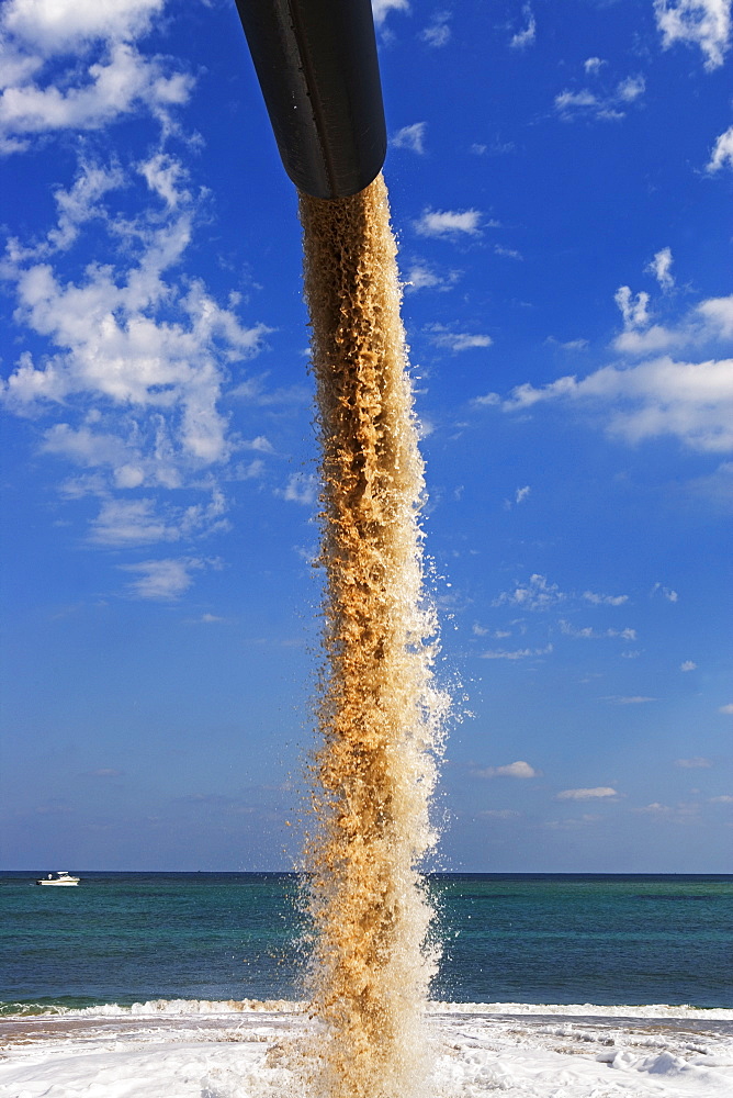 Dredger spraying sand on beach