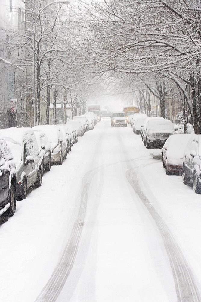 USA, New York City, snowy street with rows of parked cars