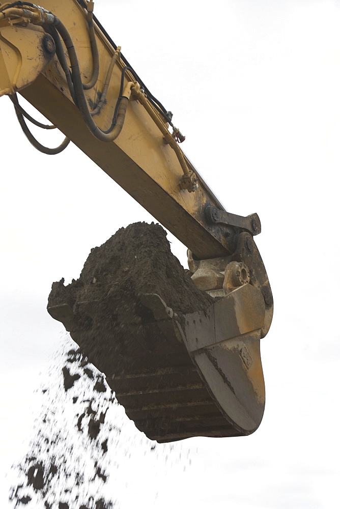 Low angle view of digger scoop full of soil