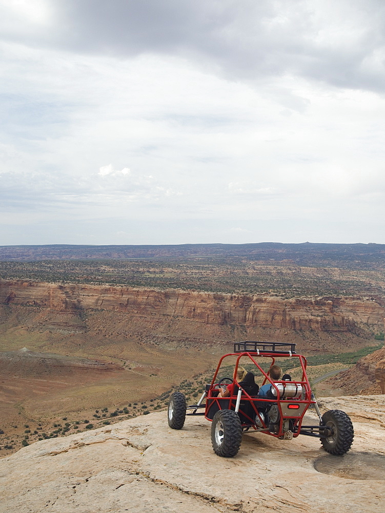 People in off-road vehicle at edge of cliff