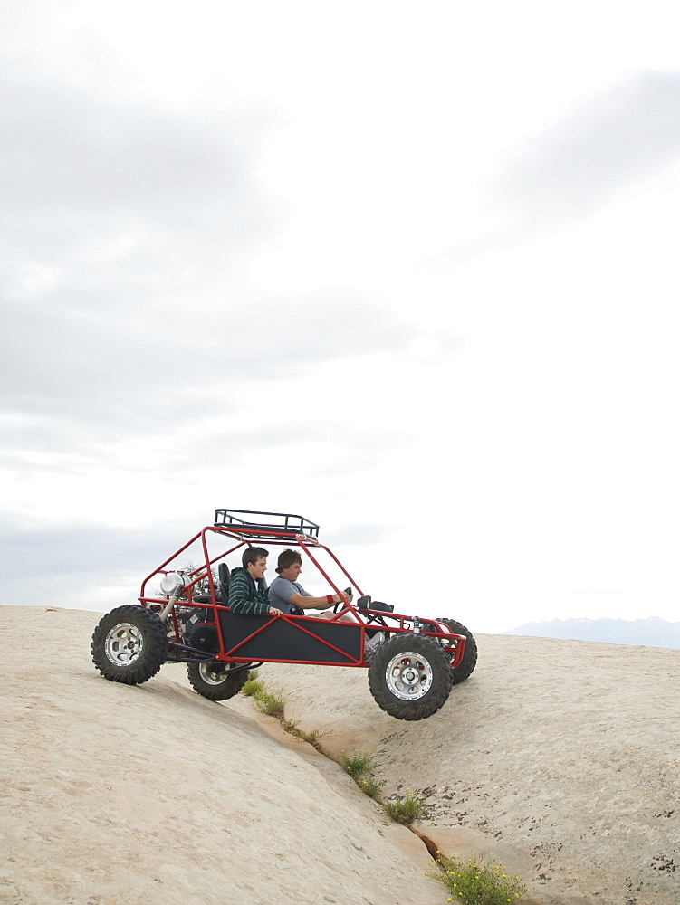 People in off-road vehicle on rock formation