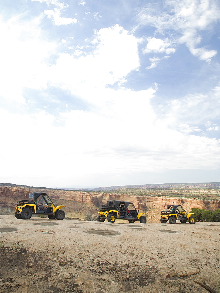 People in off-road vehicles on rock formation