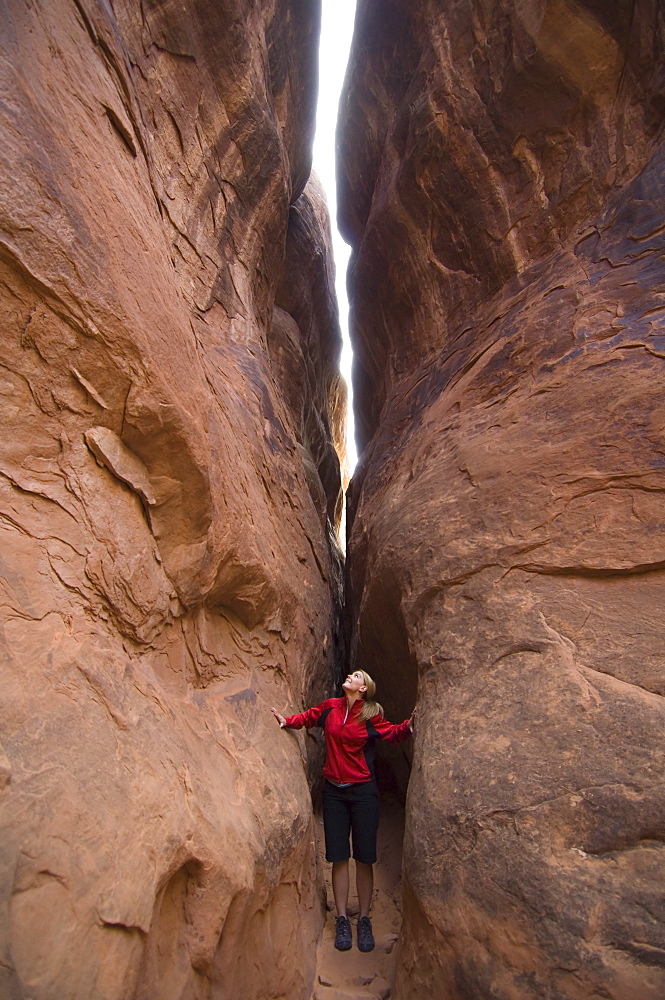 Woman looking up between rock formations