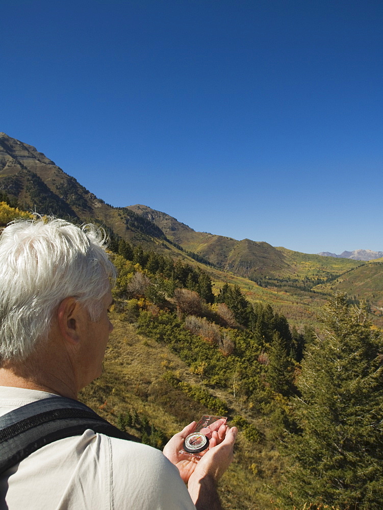 Senior man holding compass, Utah, United States