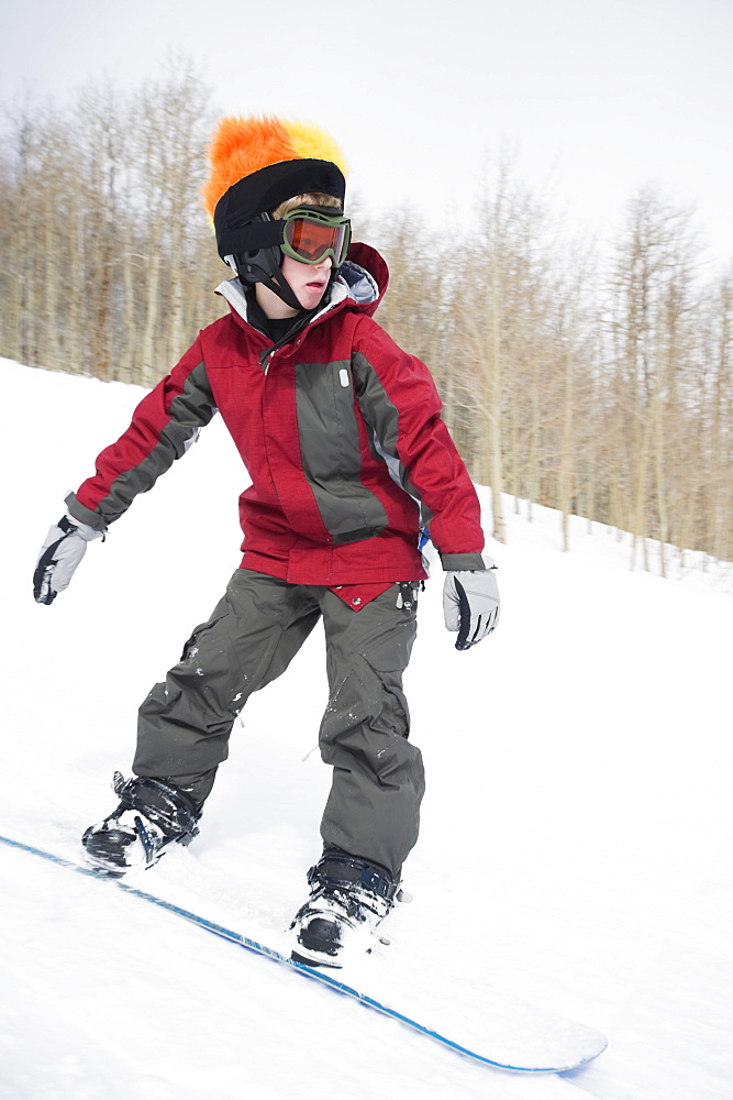 Boy snowboarding downhill