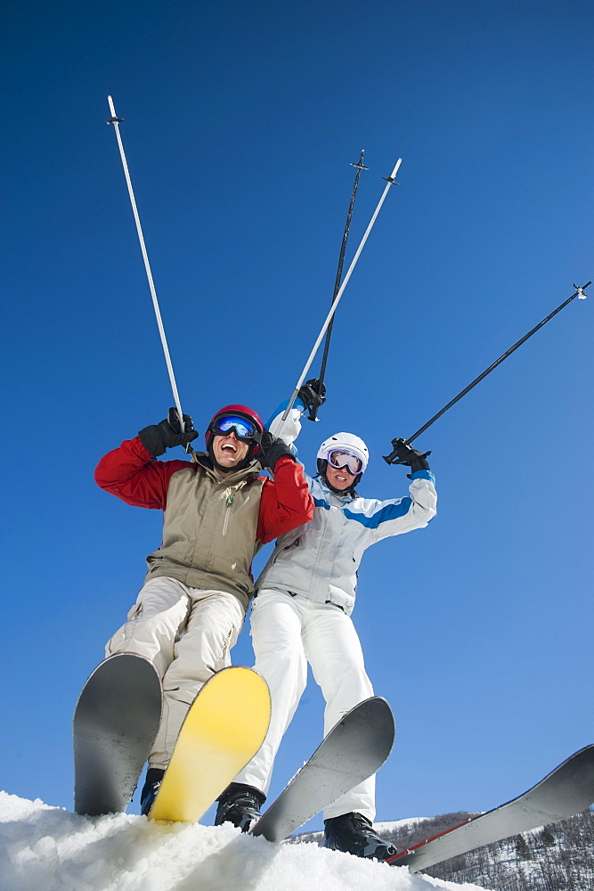 Couple with arms raised on skis