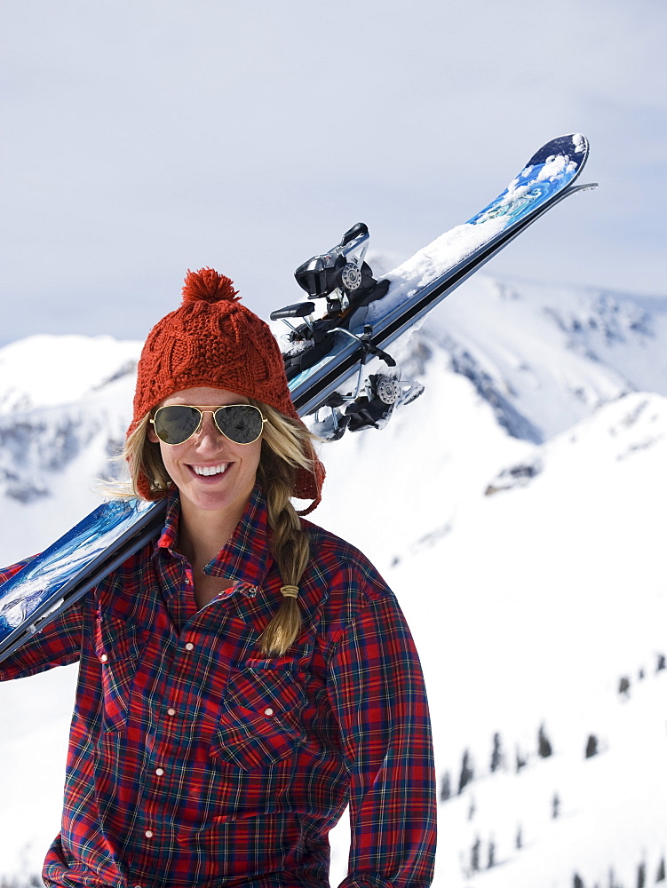 Woman holding skis on shoulder