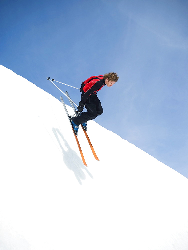 Skier dropping in to half-pipe