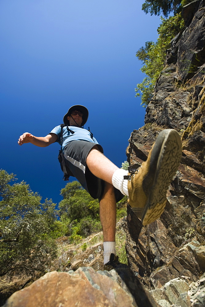 Hiker stepping down rocky trail