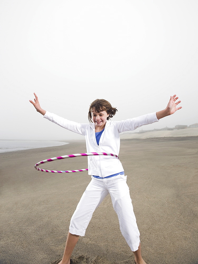 Portrait of girl with hula hoop on beach