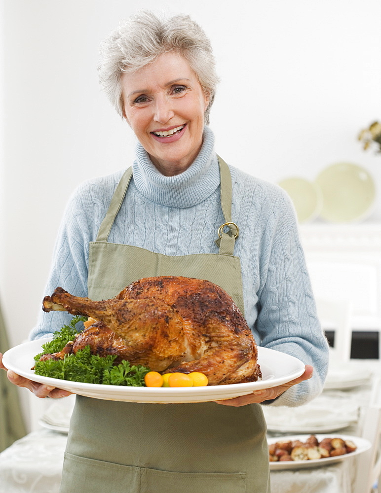 Portrait of senior woman holding Thanksgiving turkey