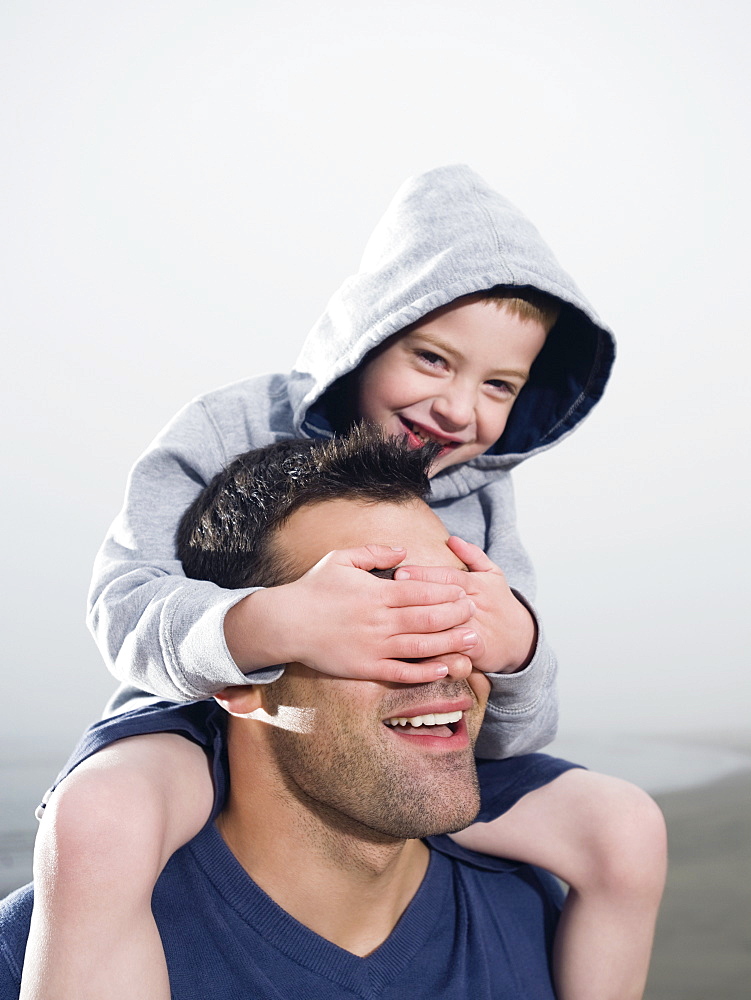 Close up of boy covering fatherâ€™s eyes