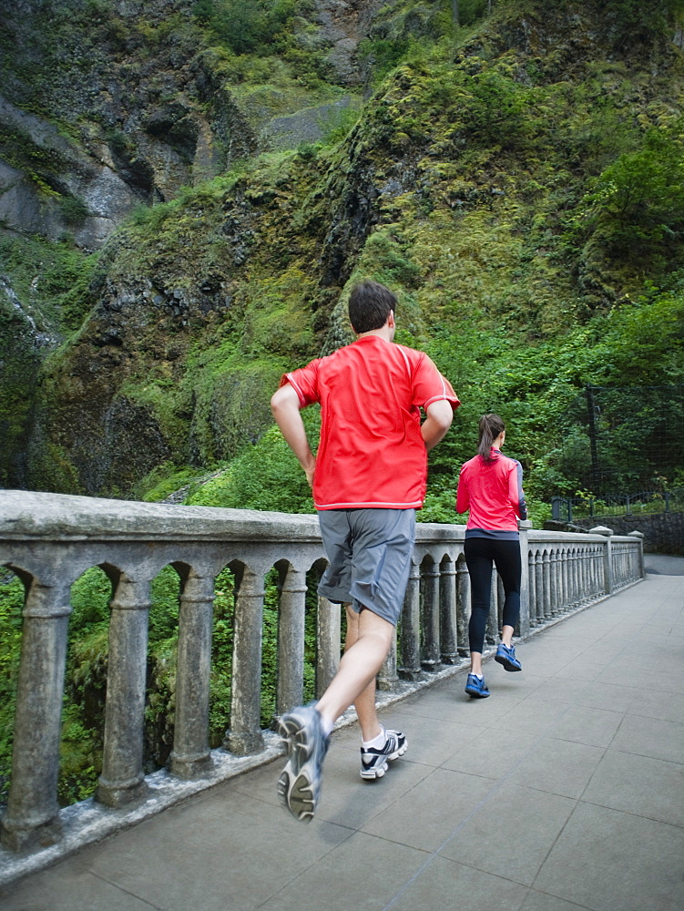 Couple running across bridge