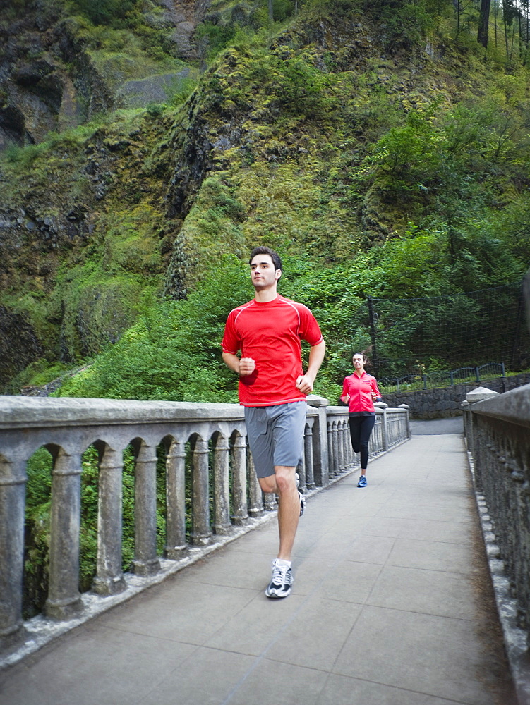 Couple running across bridge