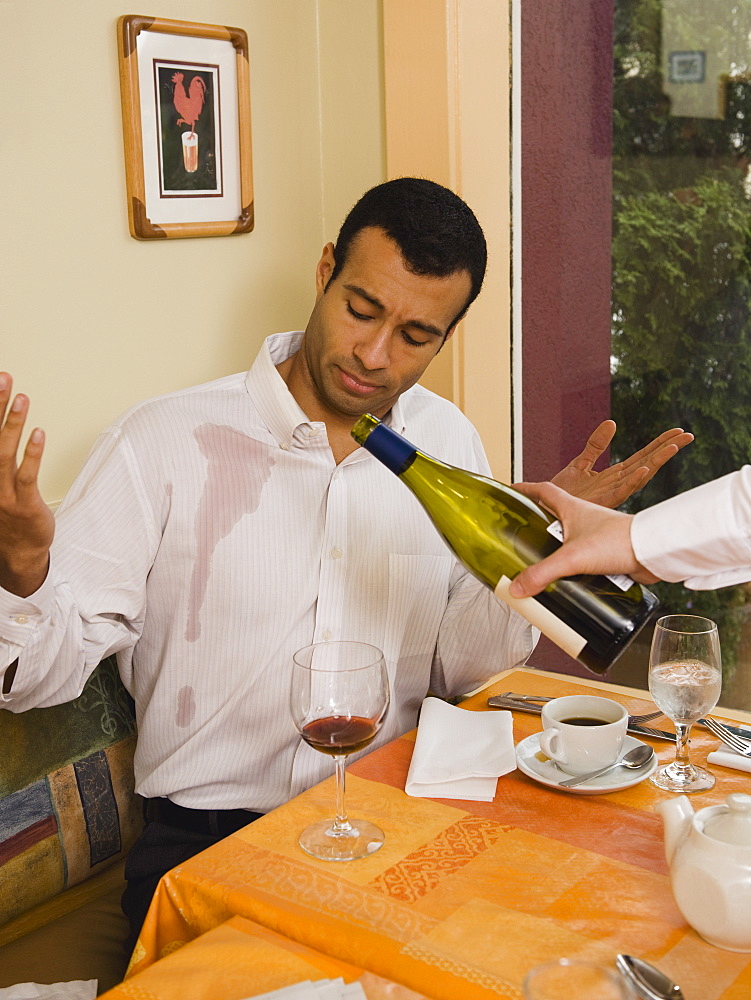 Waiter spilling wine on customer