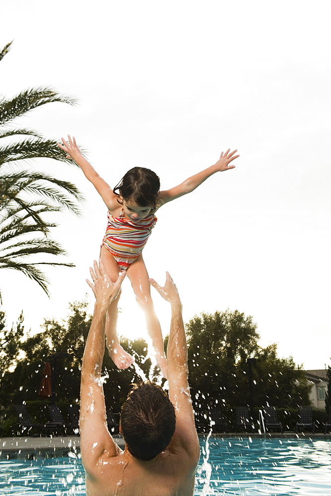 Father and daughter playing in pool