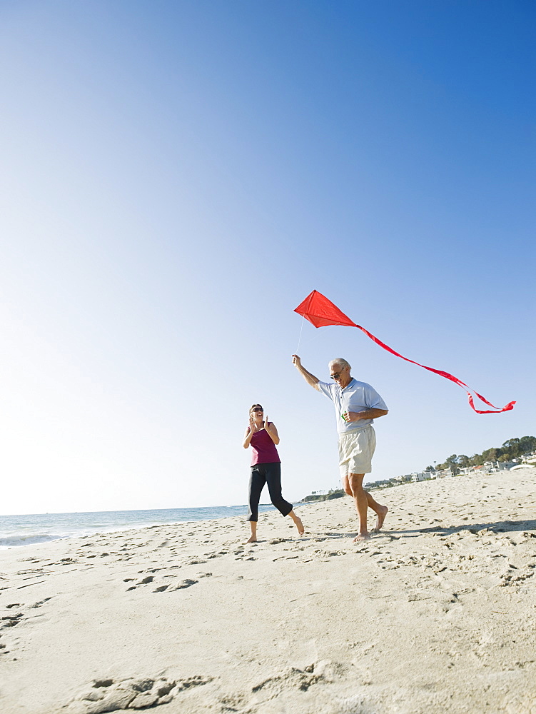 Couple flying kite on beach