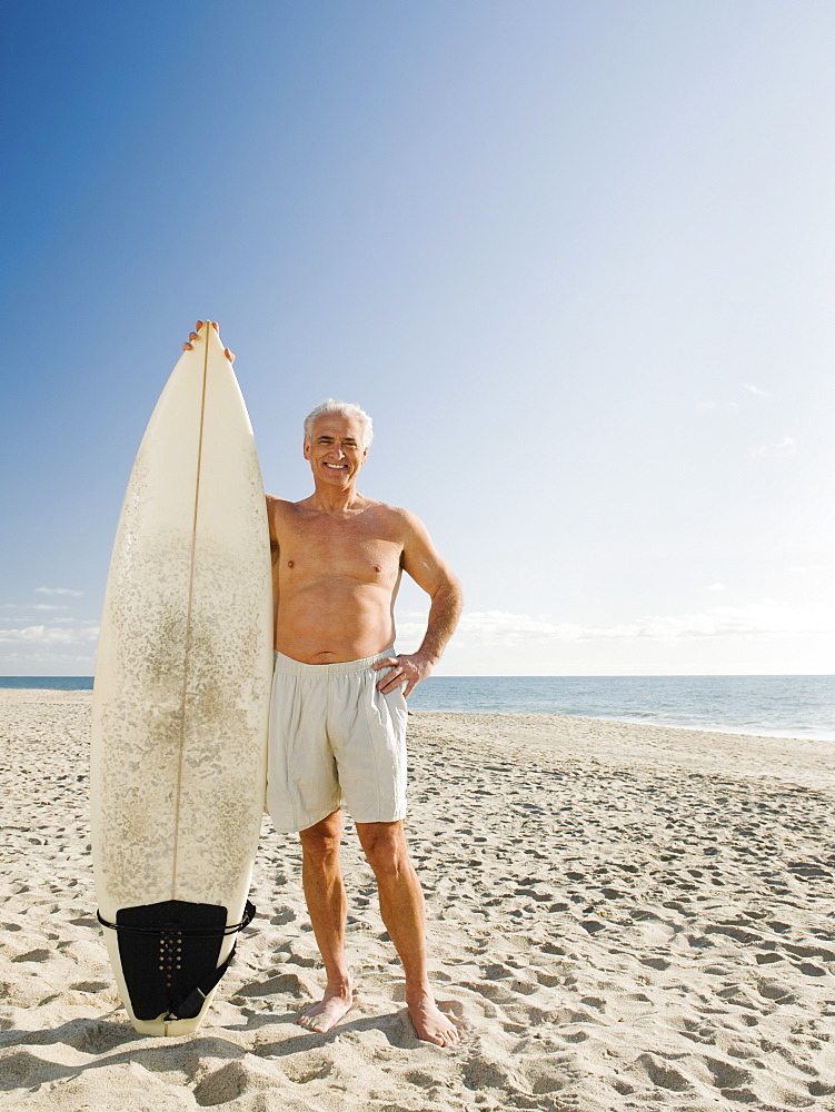 Man holding surfboard on beach