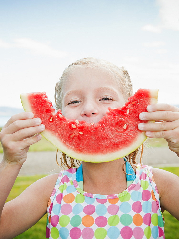 Girl (6-7) eating watermelon