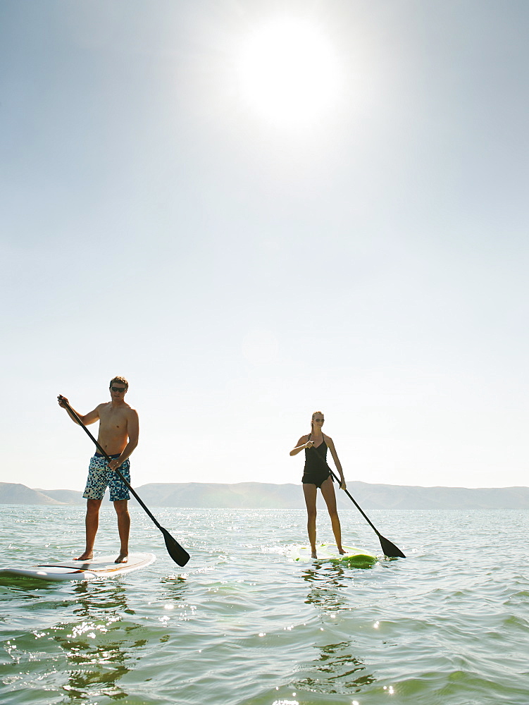 Two people standing on paddleboard