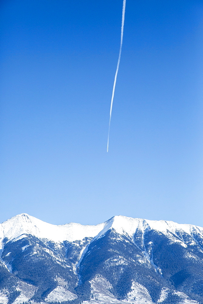 Vapor trail on clear sky above mountains, Colorado, USA