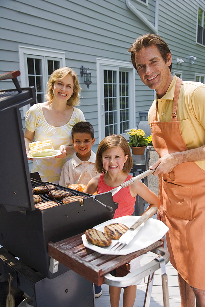 Family barbequing on deck