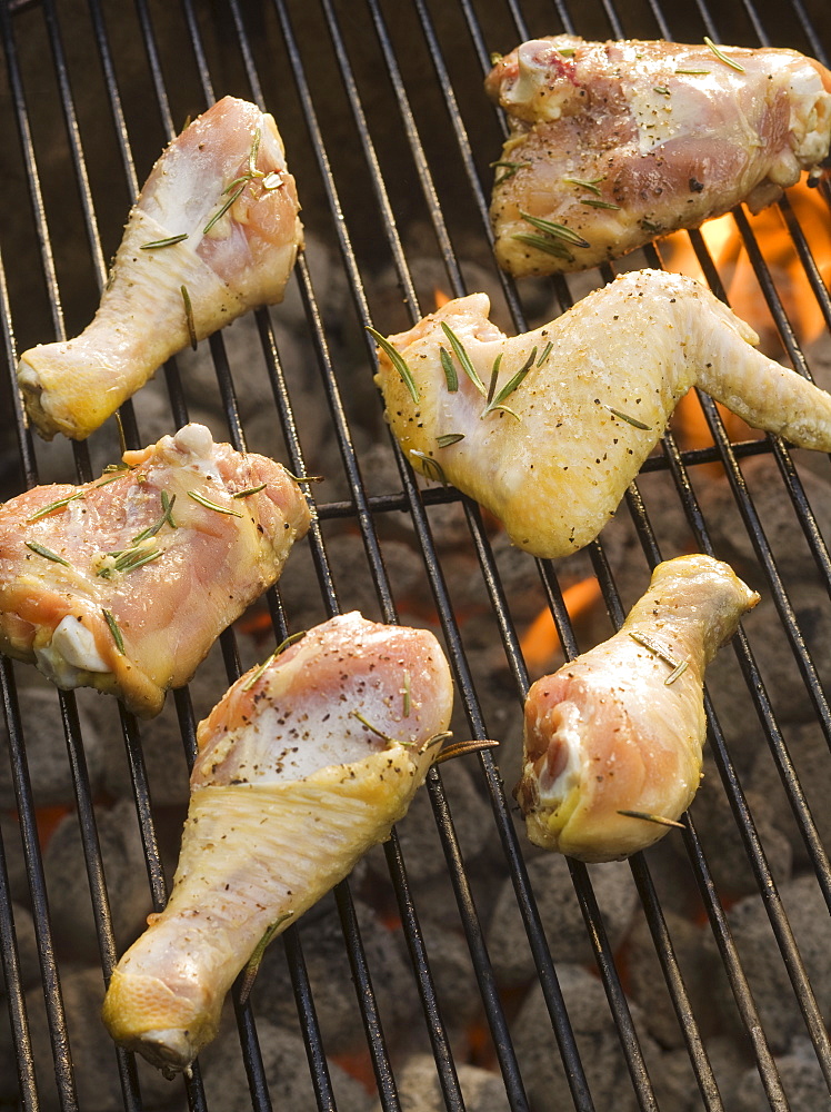 Chicken pieces cooking on grill