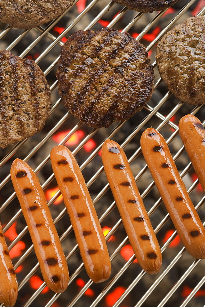 Hamburgers and hot dogs cooking on grill