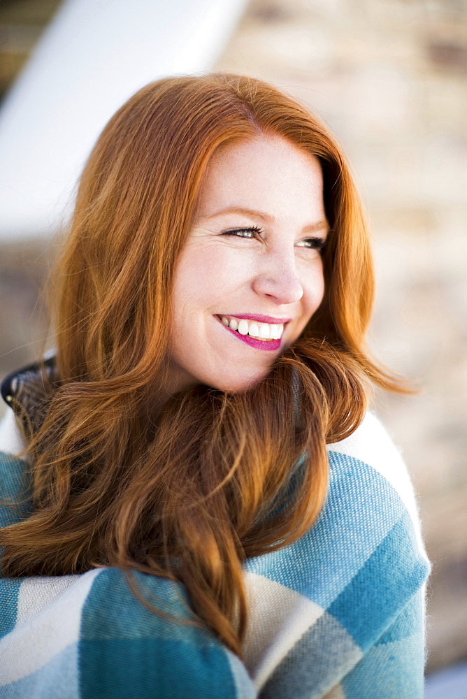 Portrait of mid adult woman wrapped in checked blanket