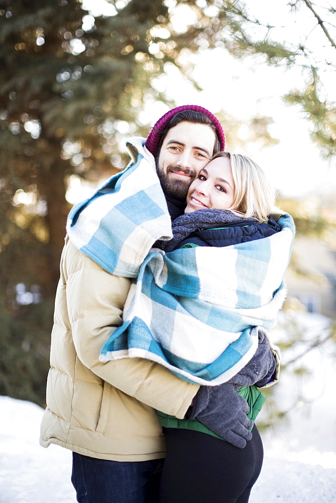 Couple wrapped in blanket hugging outdoors, Salt Lake City, Utah